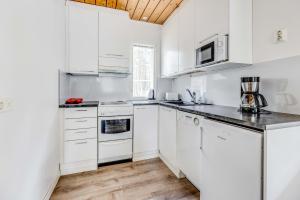 a white kitchen with white cabinets and appliances at Johtojuku 1 in Kalajoki