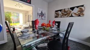 a dining room with a glass table and chairs at Stunning Holiday Home. Free Parking. in Manchester