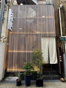 大阪的住宿－Hotel 草石庵，建筑前有盆栽植物的楼梯