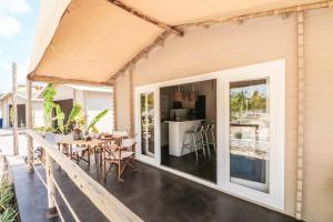 an open deck with a table and chairs on a house at Mwezi Boutique Resort in Jambiani