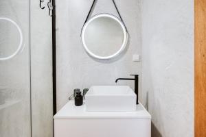 a white bathroom with a sink and two mirrors at Casa das Andorinhas - 1 bedroom apartment sleeps 4 in Câmara de Lobos +19 photos