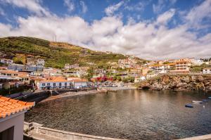 a town on a hill with a river and houses at Casa das Andorinhas - 1 bedroom apartment sleeps 4 in Câmara de Lobos