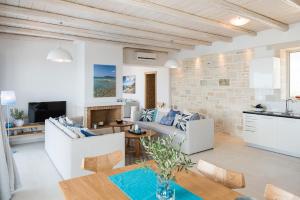 a living room with white furniture and a brick wall at Falasarna Luxury Villas in Falasarna
