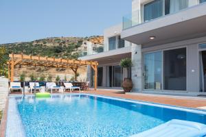a swimming pool in front of a house at Falasarna Luxury Villas in Falasarna