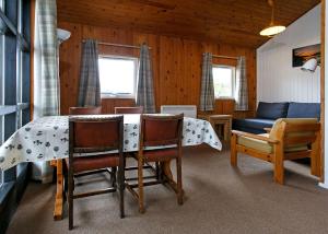 a living room with a table and chairs and a couch at Lochearnhead Loch Side in Lochearnhead