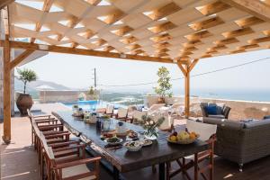 a dining table on a patio with a view of the ocean at Falasarna Luxury Villas in Falasarna