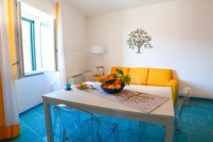 sala de estar con mesa y sofá amarillo en Amalfi Coast Ncopp' a' Scalinatella, en Scala
