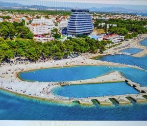 an aerial view of a beach with a large building at Apartments M&R ŠPADINA in Vodice