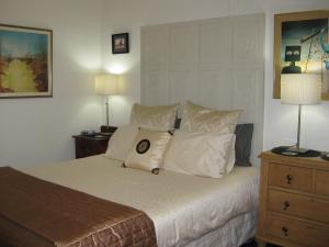 1 dormitorio con 1 cama con almohadas y 2 lámparas en Three Chimneys Bed and Breakfast Boutique Guest House en Albany