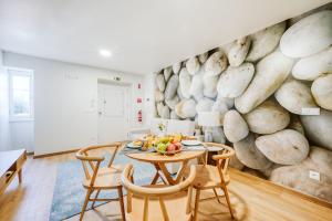 a dining room with a stone wall with a table and chairs at Casa do Calhau - 1 bedroom apartment sleeps 4 in Câmara de Lobos