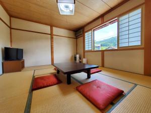 a room with a table and a tv in it at Oyado Sumire-so in Takayama