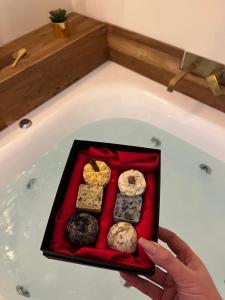 a person holding a tray of donuts in a bath tub at Borgo Marinaro Suite in Salerno