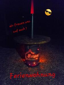 una mesa con luz roja y una vela en Ferienwohnung Bauer en Böbing