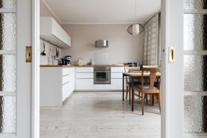 eine Küche mit weißen Schränken und einem Holztisch in der Unterkunft Haus MeerZeit Whg.2 in Cuxhaven