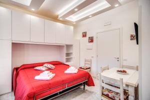 um pequeno quarto com uma cama vermelha e uma mesa em Casa Lolla em Sorrento