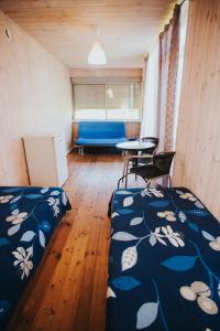 Habitación con 2 camas, mesa y sofá en SaulesKempings, en Mērsrags