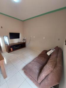 a large couch in a living room with a flat screen tv at Casas 5 min a pé da praia in Natal