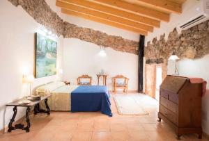 a bedroom with a bed and a table in a room at Charming Townhouse 7 PAX WIFI/AIRCON - Ca's Padrí in Llucmajor