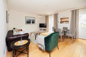 een woonkamer met een bank en een tafel bij The Bayswater Nook - Stylish 1BDR Flat in Londen