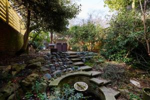 een tuin met een stenen pad en een stenen brug bij The Bayswater Nook - Stylish 1BDR Flat in Londen