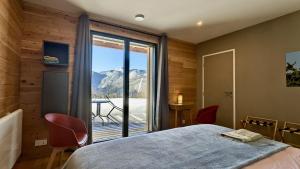 a bedroom with a bed and a large window with a view at Balcons de Sorgeat - Chambres d'hôtes in Sorgeat
