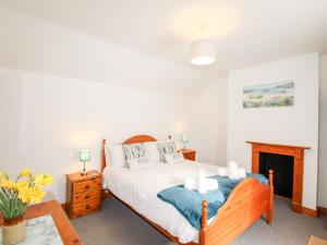 a bedroom with a bed and a fireplace at Angel Cottage in Weymouth