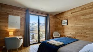 een slaapkamer met een bed en een groot raam bij Balcons de Sorgeat - Chambres d'hôtes in Sorgeat
