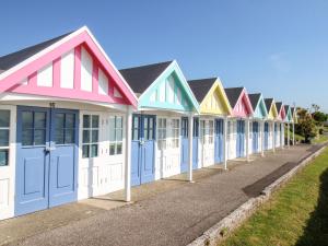 a row of colourful beach houses on a street at Angel Cottage in Weymouth