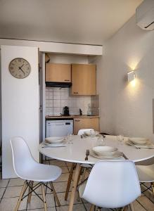 a kitchen with a table and chairs and a clock at Résidence Graziella Studio 308 in Juan-les-Pins +10 photos
