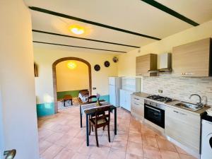 a kitchen with a table and a dining room at Appartamento Il Torrione in Ansedónia