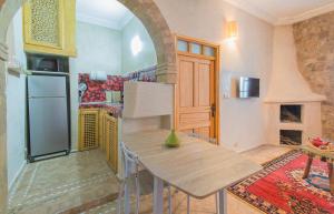 a kitchen with a table and a refrigerator at Stella 2 - appartement spacieux avec cheminée medina Essaouira in Essaouira