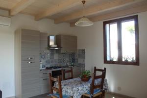 里斯佩希亞的住宿－Agriturismo Mimosa，厨房配有桌椅和窗户。