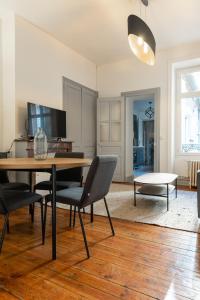 ein Wohnzimmer mit Esstisch und Stühlen in der Unterkunft Le Théodore Bac-Spacieux T2 - Coup de coeur en face de la gare des Bénédictins in Limoges