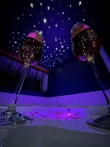 due bicchieri da vino seduti sopra un tavolo di L'Eclipse maison romantique avec Jacuzzi 