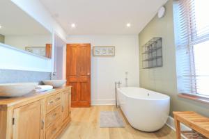 a bathroom with a large white tub and a sink at Terracotta House in Bristol