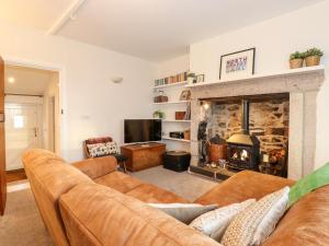 Una sala de estar con un sofá y una chimenea. en Garden Cottage, en Chathill