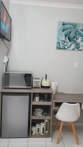 einen Schreibtisch mit einer Mikrowelle und einem Stuhl in einem Zimmer in der Unterkunft Refreshing Space in Eden Glen, Johannesburg, SA in Edenvale