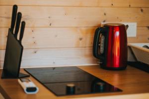 a red coffee pot sitting on top of a table at Liepa SaulesKempings in Mērsrags