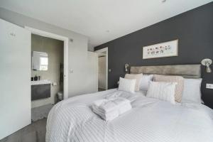 a bedroom with a large white bed with white pillows at Stunning 3 Bed 3 Bath Townhouse In City Centre in London