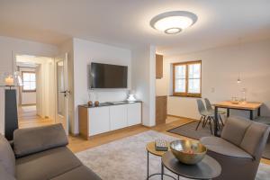 a living room with a couch and a tv at Landhaus Wiederkehr in Oberstdorf