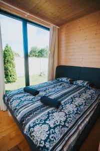 a bed with two pillows on it in a room with a window at Liepa SaulesKempings in Mērsrags