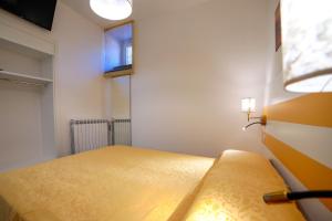 a bedroom with a yellow bed with a window at Ncopp' a' Scalinatella in Scala