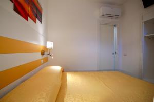 um quarto com uma cama com uma colcha amarela em Ncopp' a' Scalinatella em Scala