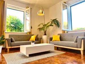 Sala de estar con 2 sofás y mesa de centro en VIlla Sunlight Sardegna, en Santa Luria
