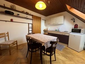 y cocina con mesa, sillas y nevera. en Cozzy apartment in nature en Zagreb