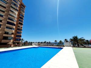 a large swimming pool next to a tall building at Marina View Apartment in Fuengirola