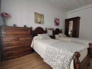 a bedroom with two beds and a dresser at Casa Cervantes Toledo in Toledo