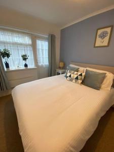 a bedroom with a large white bed with a window at Eremue Court Hideaway Yarmouth IOW in Yarmouth +3 photos
