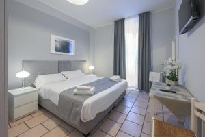 a bedroom with a large white bed and a table at Affittacamere Berzi in Trieste