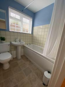 a bathroom with a tub and a toilet and a sink at Eremue Court Hideaway Yarmouth IOW in Yarmouth